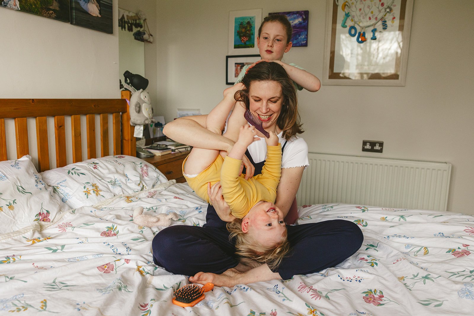 Family fun, mother and children playing on bed.